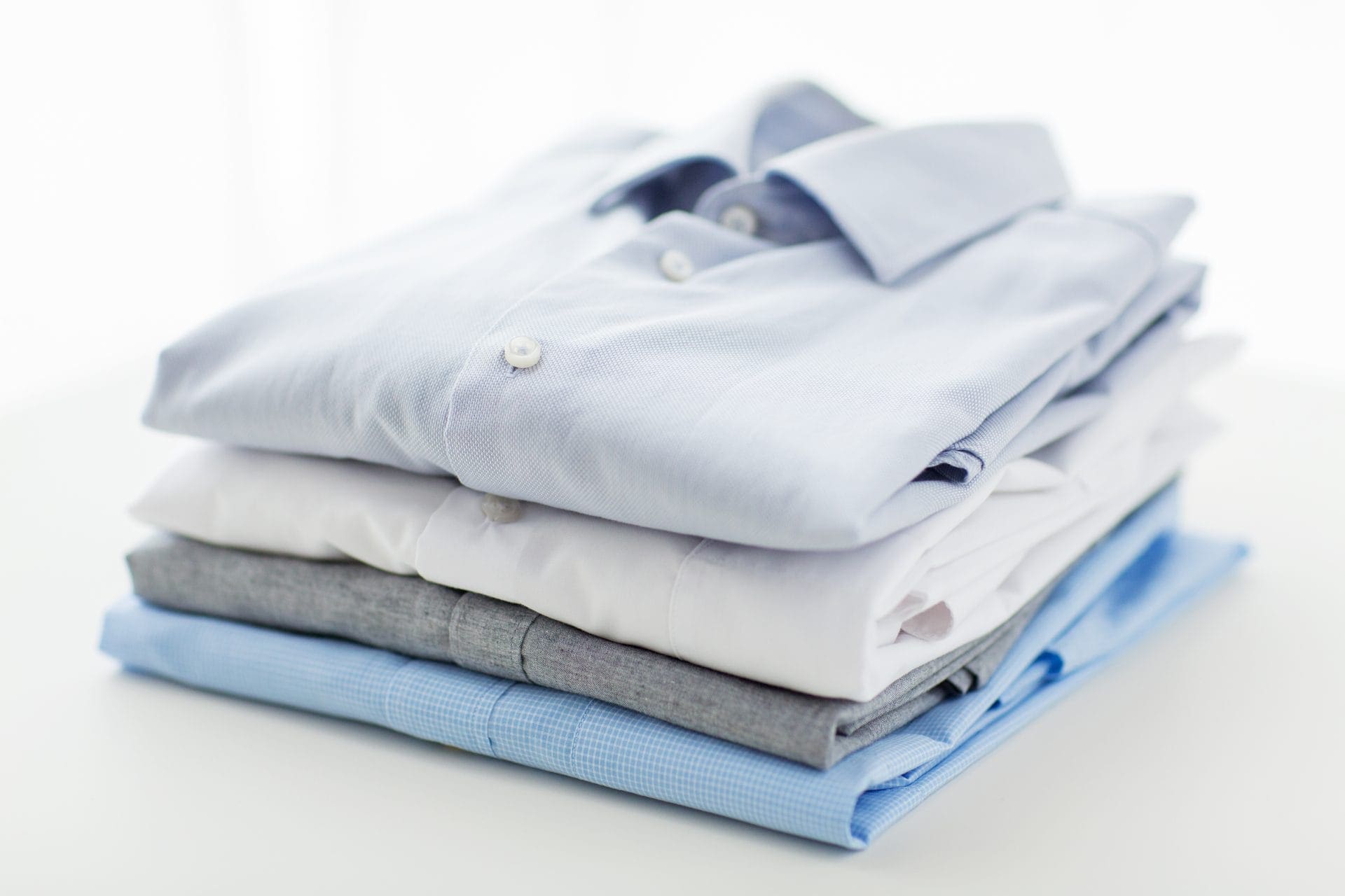 A woman ironing a shirt on an ironing board.